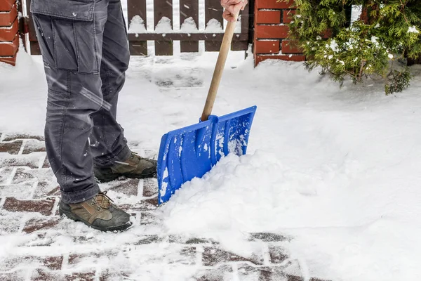 Mann räumt nach Schneesturm Schnee vom Gehweg — Stockfoto