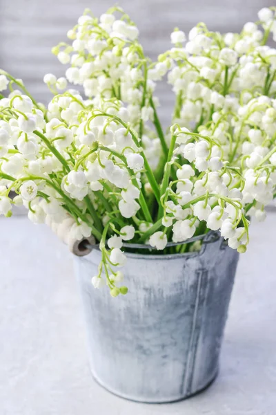 Lilly of the valley flowers in silver bucket — Stock Photo, Image