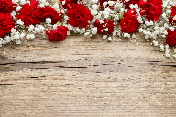 Red carnations on wooden background — Stock Photo, Image