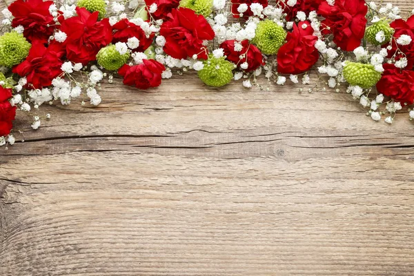 Red carnations on wooden background — Stock Photo, Image
