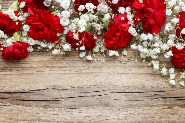 Red carnations on wooden background — Stock Photo, Image