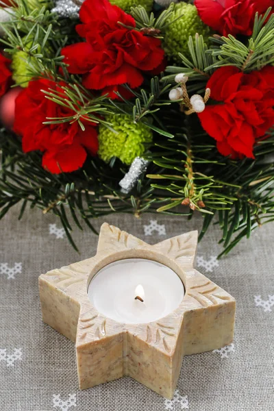 Candle holder in star shape in front of floral christmas decorat — Stock Photo, Image