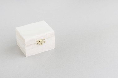 Woman paints on white color a wooden box.