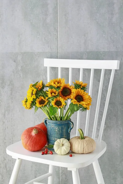 Bouquet de tournesols et de citrouilles colorées sur chai en bois blanc — Photo