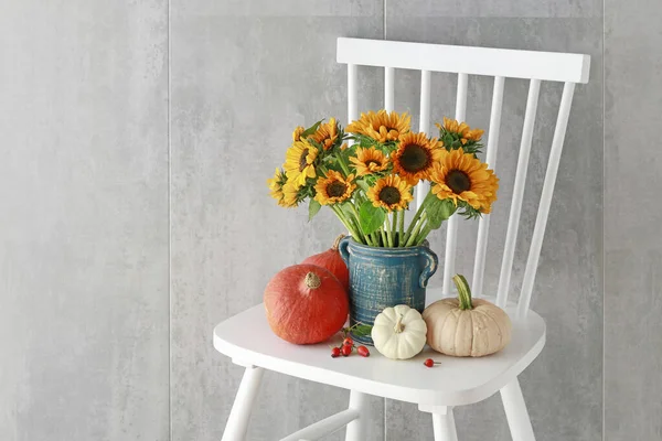 Bouquet de tournesols et de citrouilles colorées sur chai en bois blanc — Photo