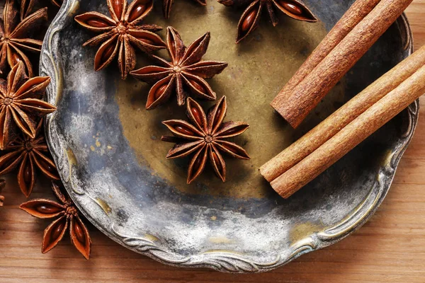 Anise seeds and cinnamon sticks on vintage plate. — Stock Photo, Image