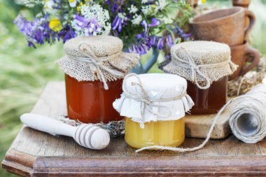 Ballı kavanozlar ve bahçede bir buket yabani çiçek. 