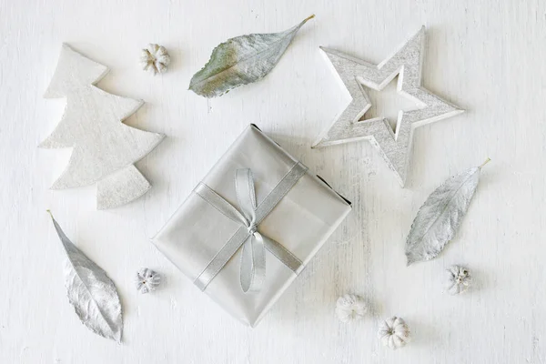 Regalo con un nastro d'argento, albero di Natale e forme a stella — Foto Stock
