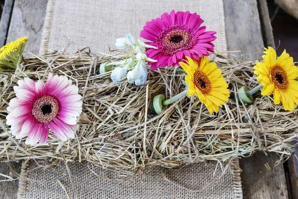 Table decoration with hay and gerbera flowers. — Stock Photo, Image