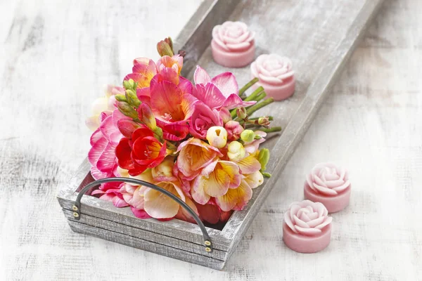 Bouquet of colorful freesia flowers on wooden tray. — Stock Photo, Image