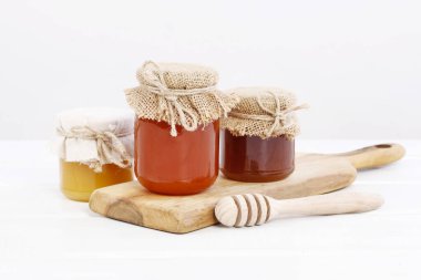 Beyaz arkaplanda izole edilmiş ballı kavanozlar. 