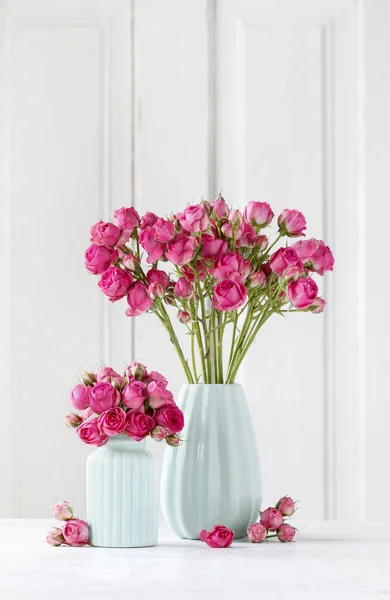 Ramo de rosas rosadas en jarrón de cerámica azul —  Fotos de Stock