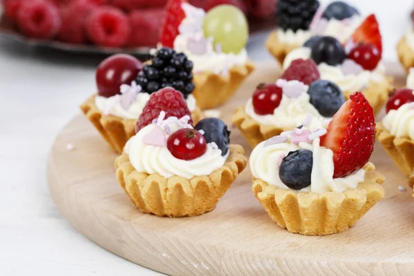 Pastelitos coloridos con frutas frescas . — Foto de Stock