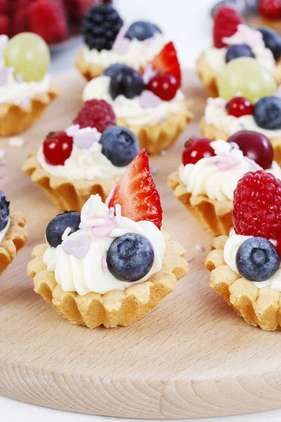 Kleurrijke cupcakes met vers fruit. — Stockfoto