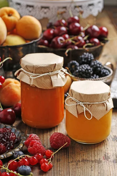 Twee potten honing en kleurrijke vruchten rond. — Stockfoto