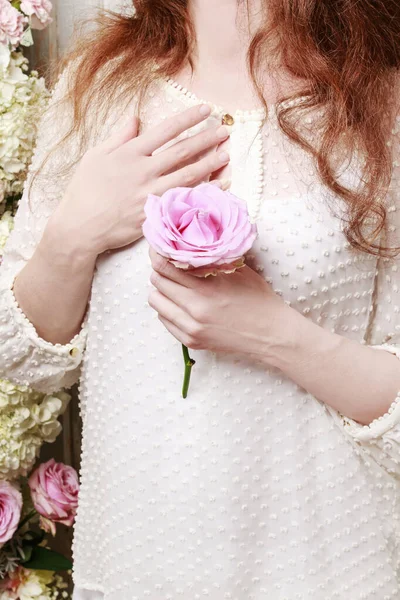 Woman holds single pink rose. — Stock Photo, Image