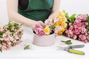 Woman shows how to make floral arrangement clipart