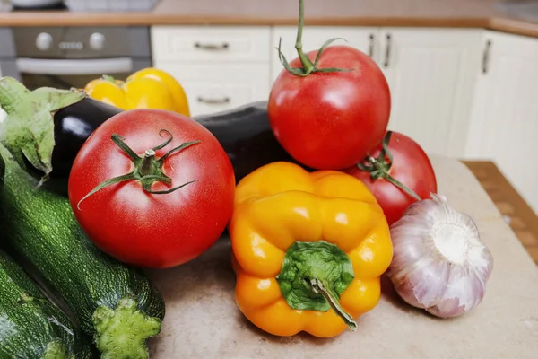 Rajčata, papriky a cukety ležící na stole ve srubu — Stock fotografie