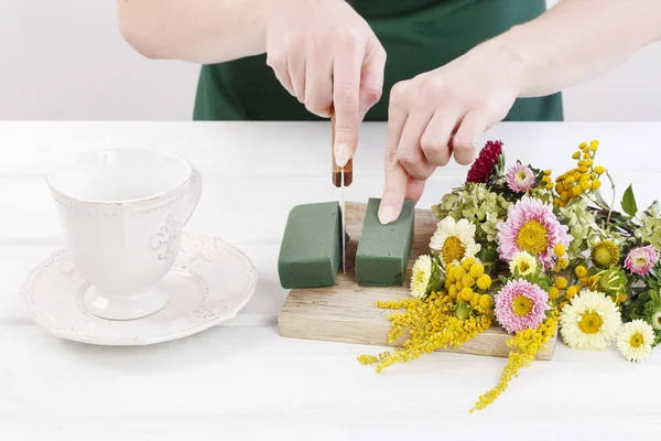 Женщина показывает, как делать цветочные композиции с летними цветами — стоковое фото