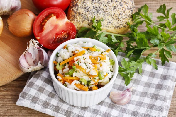 Riz bouilli aux légumes dans un bol côtelé blanc . — Photo