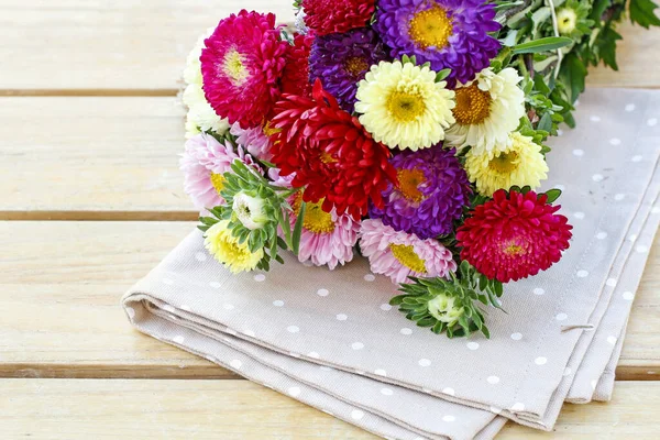 Aster flowers on wooden background.