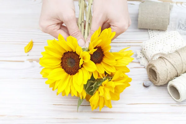 Vrouw laat zien hoe om boeket te maken met zonnebloemen — Stockfoto