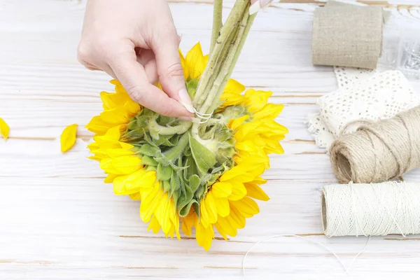 Woman shows how to make bouquet with sunflowers — ストック写真