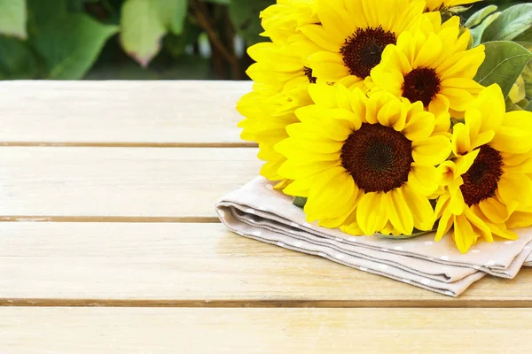 Bouquet of sunflowers on wooden table.