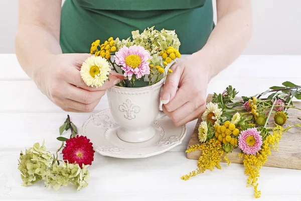 Kvinna visar hur man gör blomsterarrangemang med sommarblommor i — Stockfoto