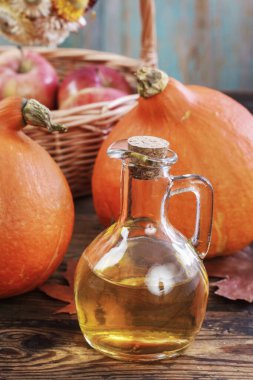 Masanın üzerinde bir şişe bal ve olgun balkabağı.. 