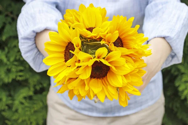 La donna sta tenendo un mazzo di girasoli . — Foto Stock