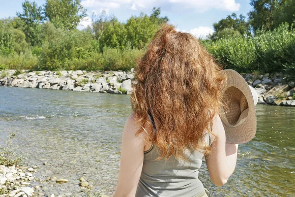 Молодая женщина идет вдоль реки в жаркий день . — стоковое фото