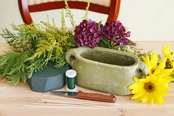 Woman shows how to make floral arrangement with sunflowers and h — Stock Photo, Image