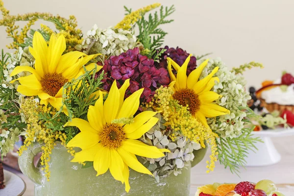Žena ukazuje, jak udělat květinové aranžmá se slunečnicemi a h — Stock fotografie
