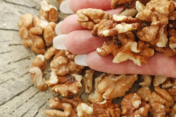 Žena drží ořechy v ruce. — Stock fotografie