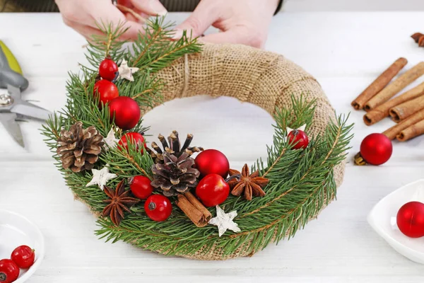 Woman shows how to make classic Christmas door wreath — Stock Photo, Image