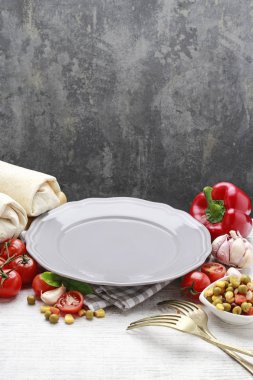 Boş tabak ve çeşitli sebzeler etrafında