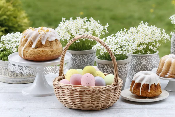 Wicker basket with Easter eggs in the garden. — Stock Photo, Image