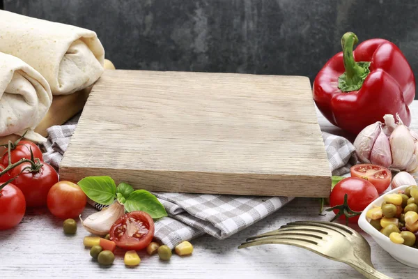 Empty wooden board and fresh vegetables around. — Stock Photo, Image