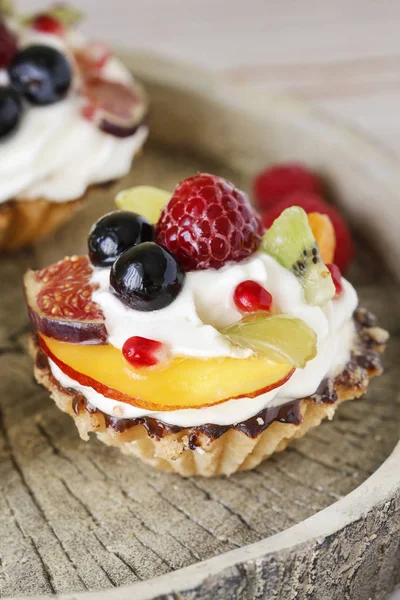 Schöne Cupcakes mit frischen Früchten dekoriert: Trauben, Pfirsich, o — Stockfoto