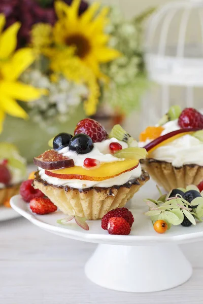 Hermosos cupcakes decorados con frutas frescas: uvas, melocotón, o —  Fotos de Stock