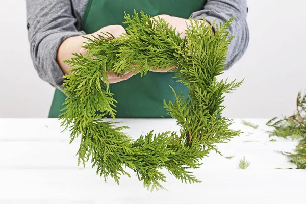 伝統的なクリスマスドアの花輪をトゥジャ小枝で作る方法 — ストック写真