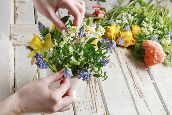 Florist på jobbet: kvinna arrangera bukett av Vårens blommor. — Stockfoto