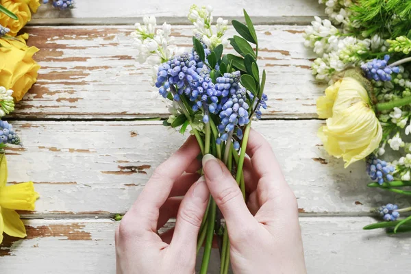 Floristin bei der Arbeit: Frau arrangiert Strauß Frühlingsblumen. — Stockfoto