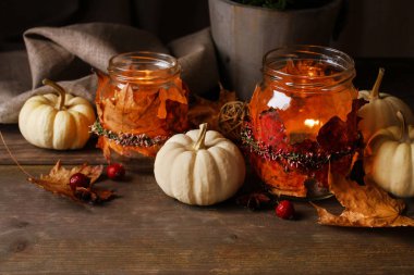 Renkli yapraklar ve fundalarla süslenmiş sonbahar feneri kavanozları.