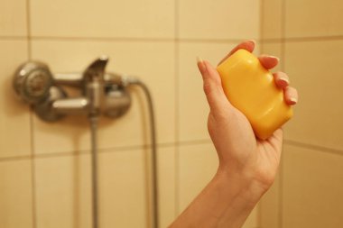 kadın bir kalıp sabun tutar. 