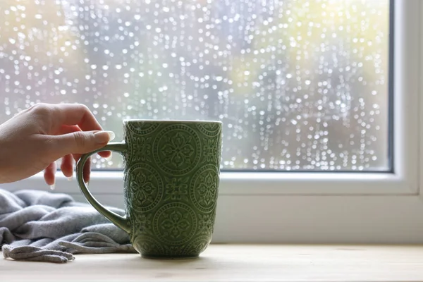 Mulher segura uma caneca verde com chá . — Fotografia de Stock