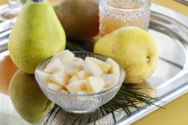 Sliced pear in a crystal bowl. Fruit drinks in the background. — 图库照片