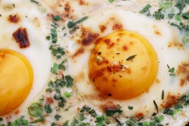 Consecutive steps of preparing fried eggs with ham and herbs