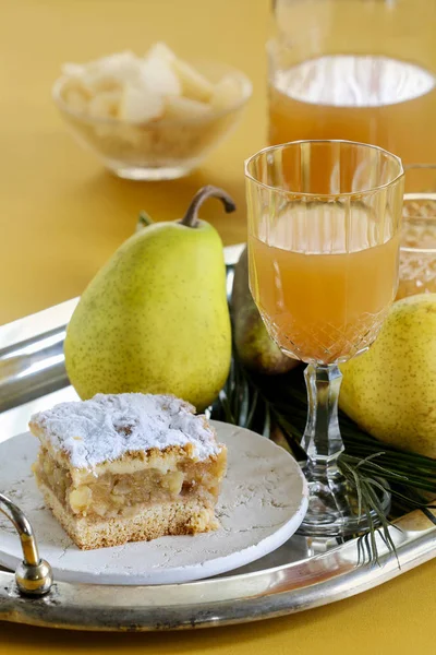 Pear drink in a crystal glass and a piece of cake on the plate. — Stock Photo, Image